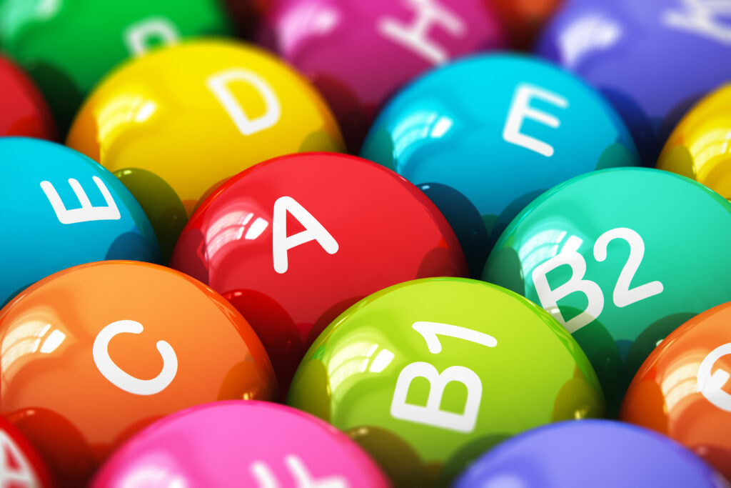 Creative abstract health lifestyle, diet and healthy eating and nutrition food concept: macro view of color balls, pills or tablets with vitamins names with selective focus effect